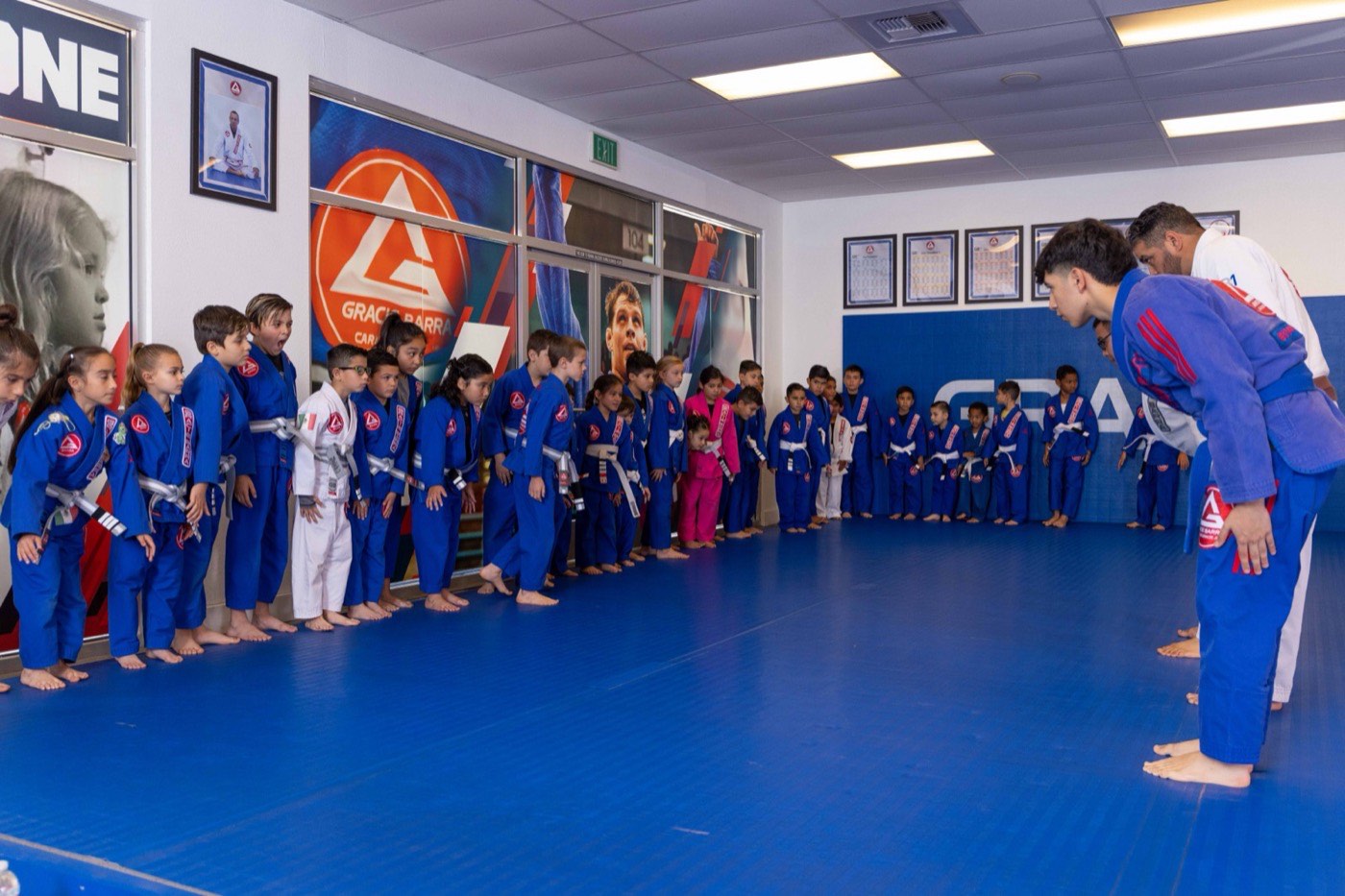 Kids bow to their instructors at the start of class